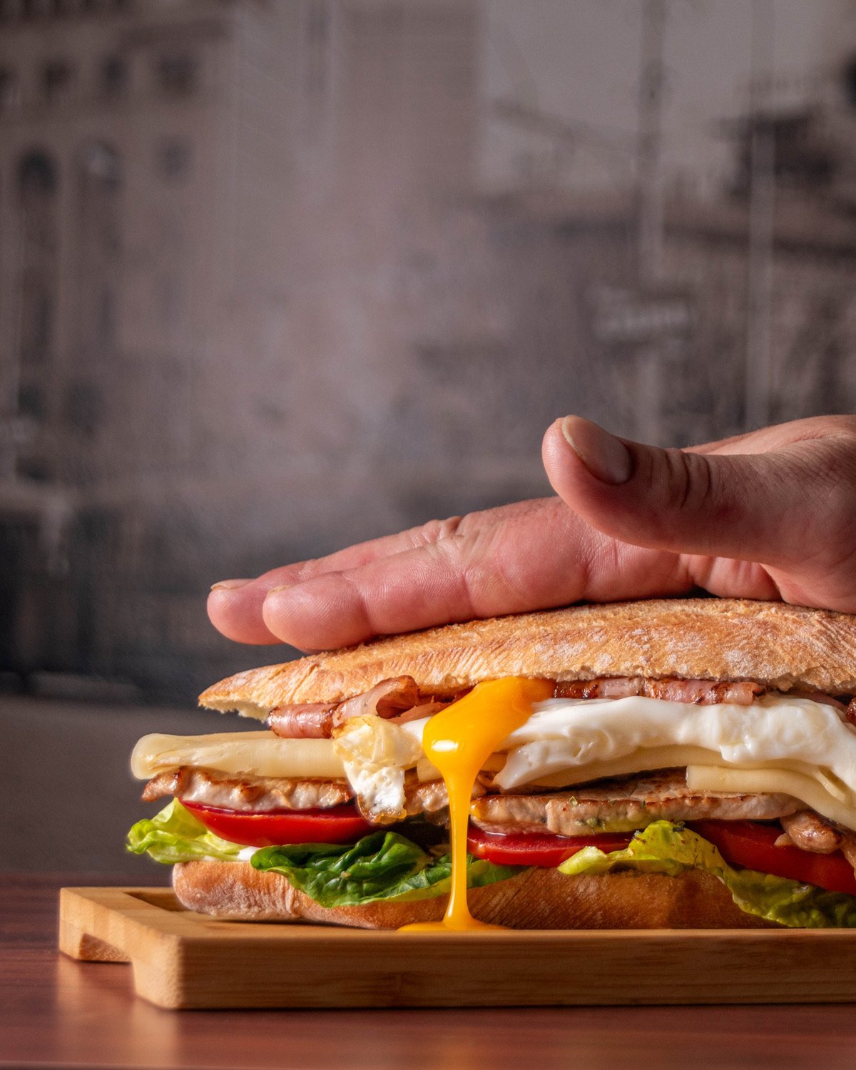 Sándwich con huevo escurriendo — fotografía profesional